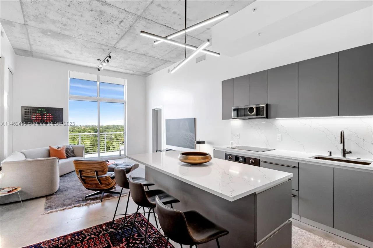 Modern Kitchen in The Meridian Condo with High Ceilings and Floor-to-Ceiling Windows Overlooking Lush Greenery