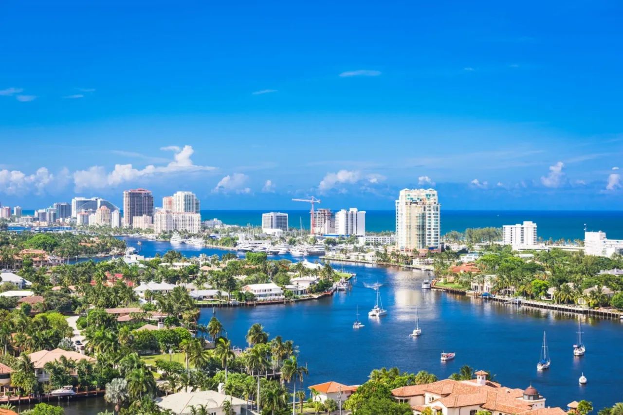 Water Canals With Distant High-Rise Buildings, Ocean Scenery, and Lush Greenery