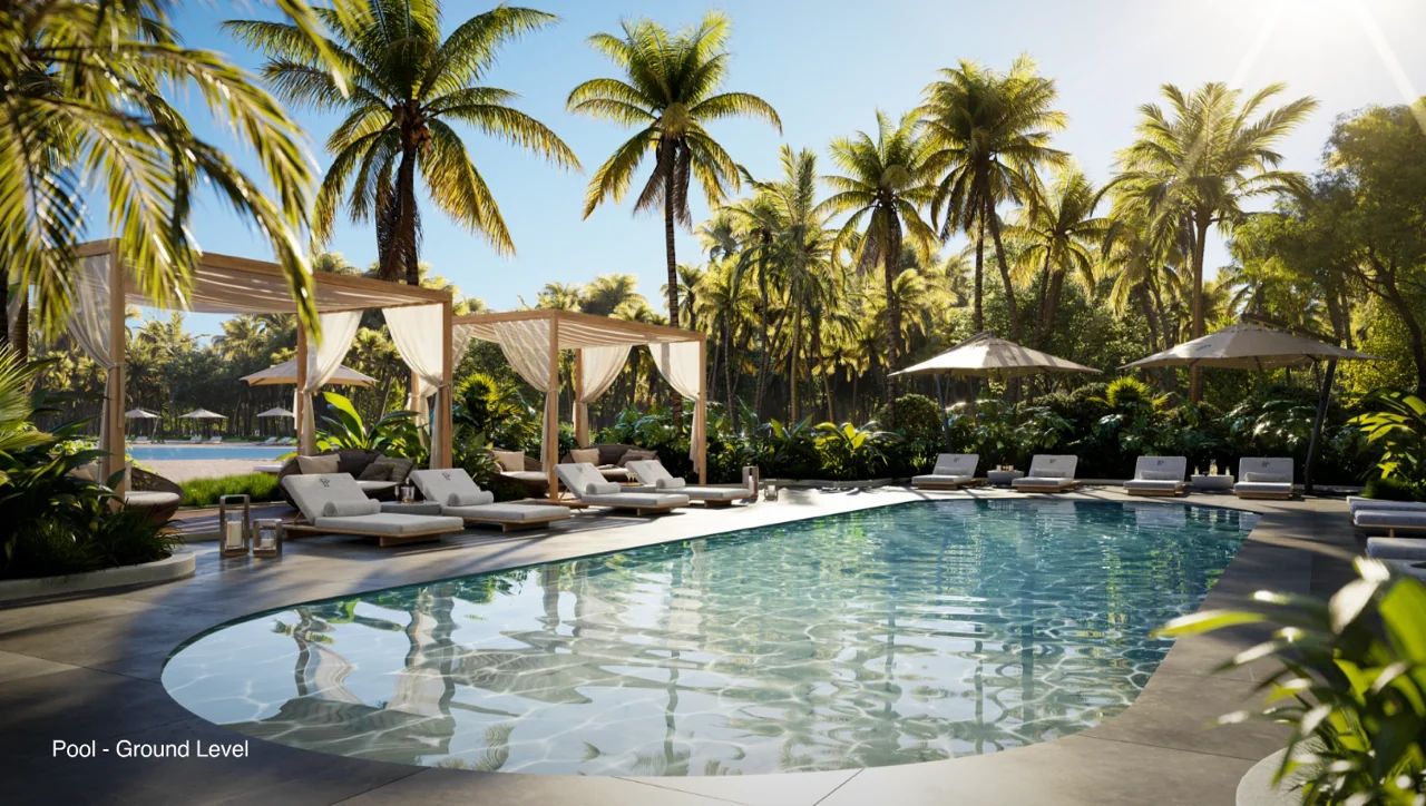 Роскошная зона отдыха у бассейна в Уан-Парк Тауэр с частными кабинками и пышной тропической растительностью в сообществе SoLé Mia в Норт-Майами