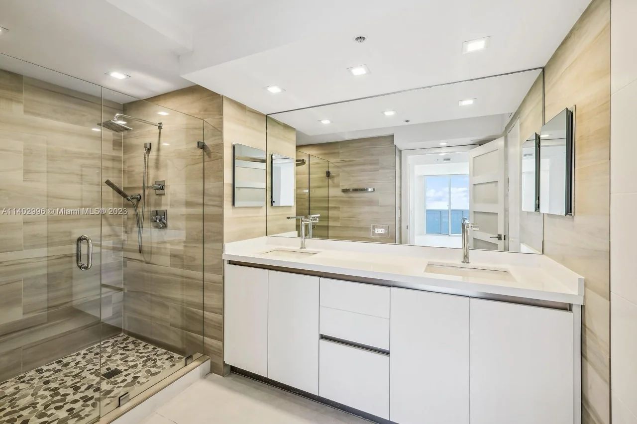 Elegant Bathroom Interior at La Gorce Palace Featuring Marble Floors, Roman Tub, and Modern Double Vanities With a Serene Ambiance