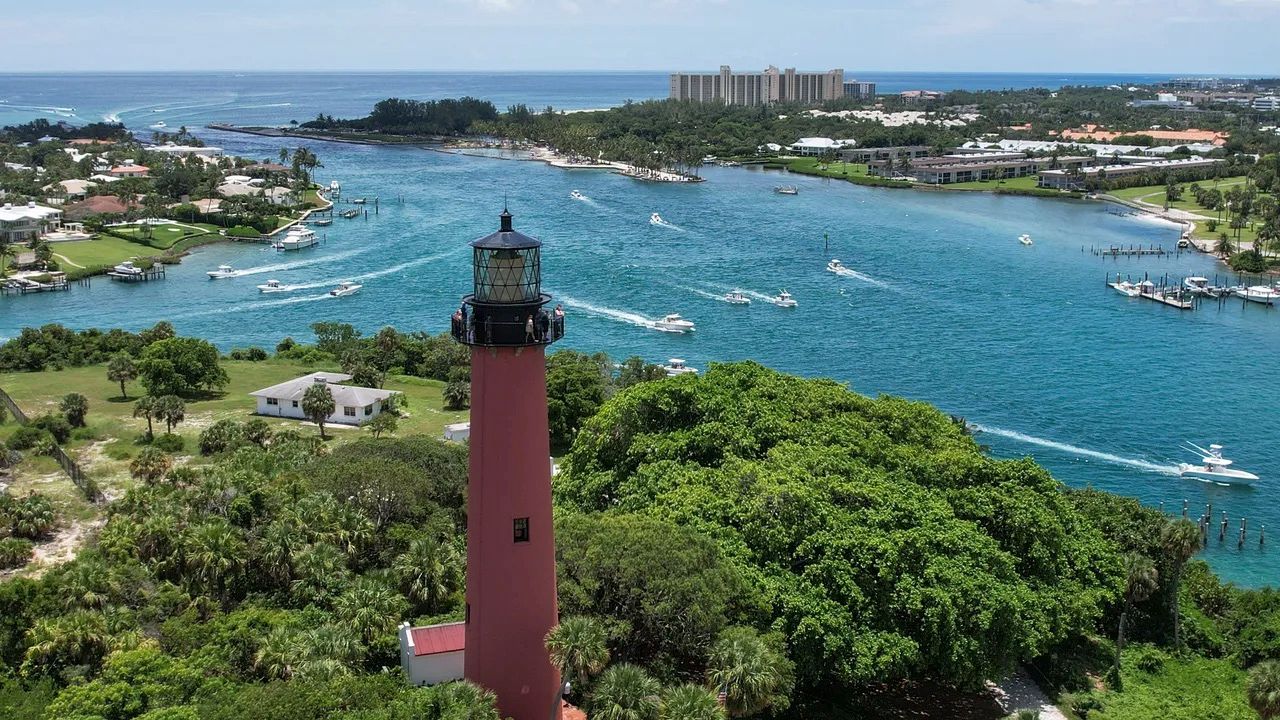 El Hist&oacute;rico Faro De La Entrada De J&uacute;piter Se Alza Majestuosamente Contra El Tel&oacute;n De Fondo Del Barrio De J&uacute;piter, Simbolizando La Herencia Cultural De La Ciudad Y Su Compromiso Con La Preservaci&oacute;n De La Naturaleza