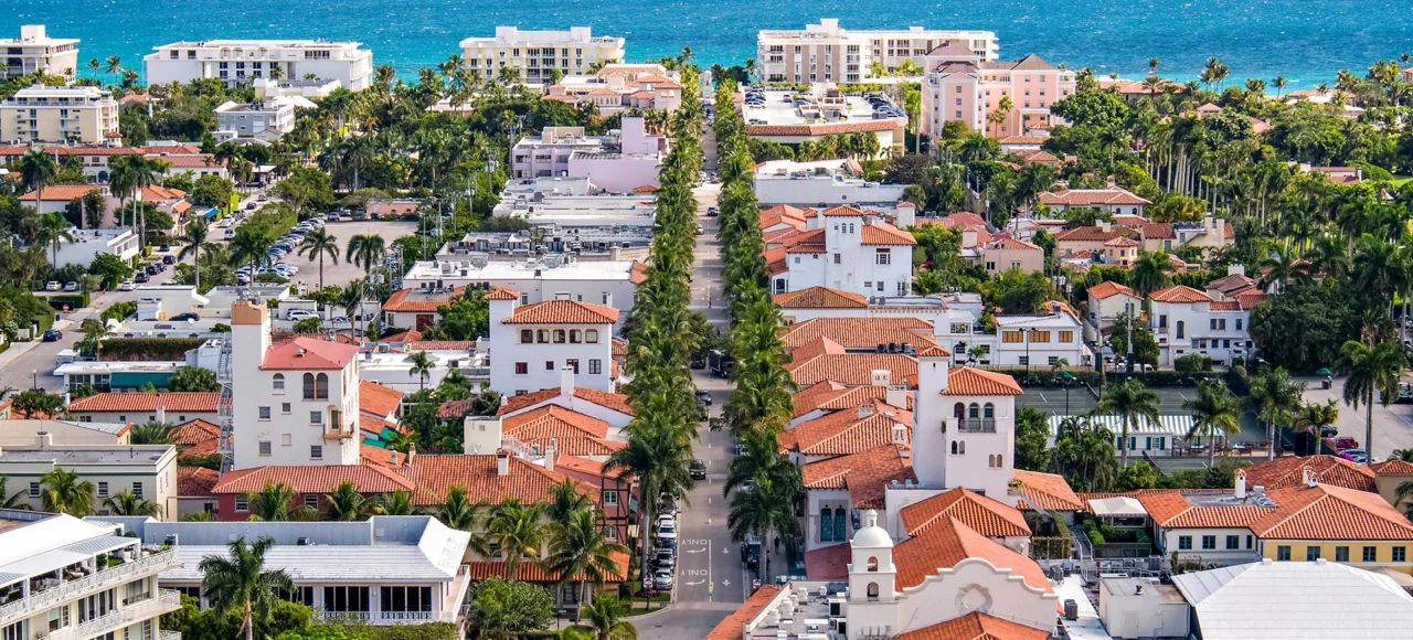Paisaje De Los Barrios De J&uacute;piter Con Calles Alineadas Con Palmeras, Arquitectura Costera Y Las Claras Aguas Azules Del Atl&aacute;ntico De Fondo, Destacando El Ambiente Sereno De La Ciudad