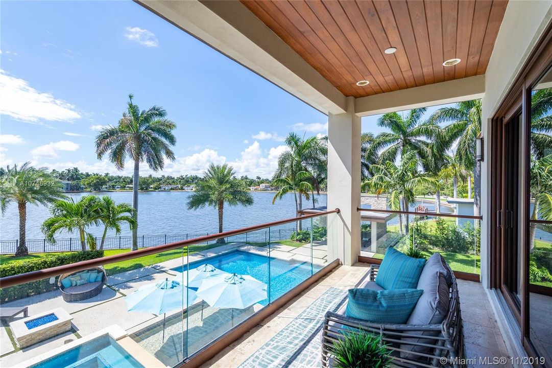 Enjoy the Second Floor Master Private Balcony.  Glass railings offer Unobstructed Water and Pool Views.  Warm details such as marble floor, wood handrail and tongue & groove covered ceiling.