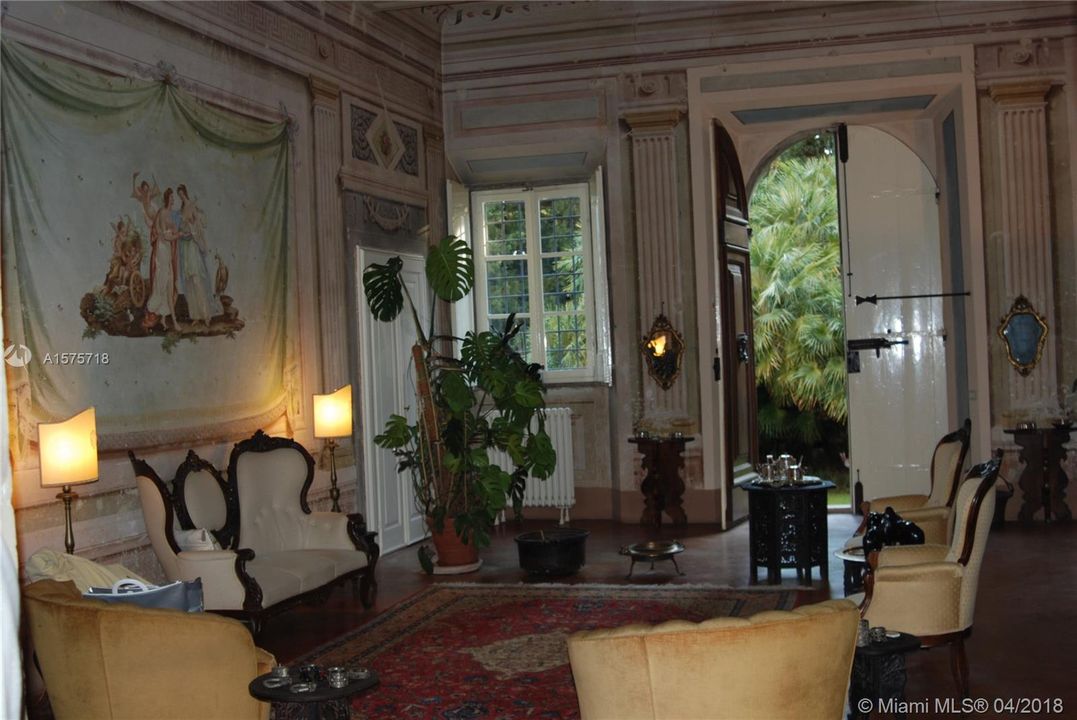 Living room with stone floors, handcarved entry doors, and spectacular murals handpainted onto the walls and ceilings.