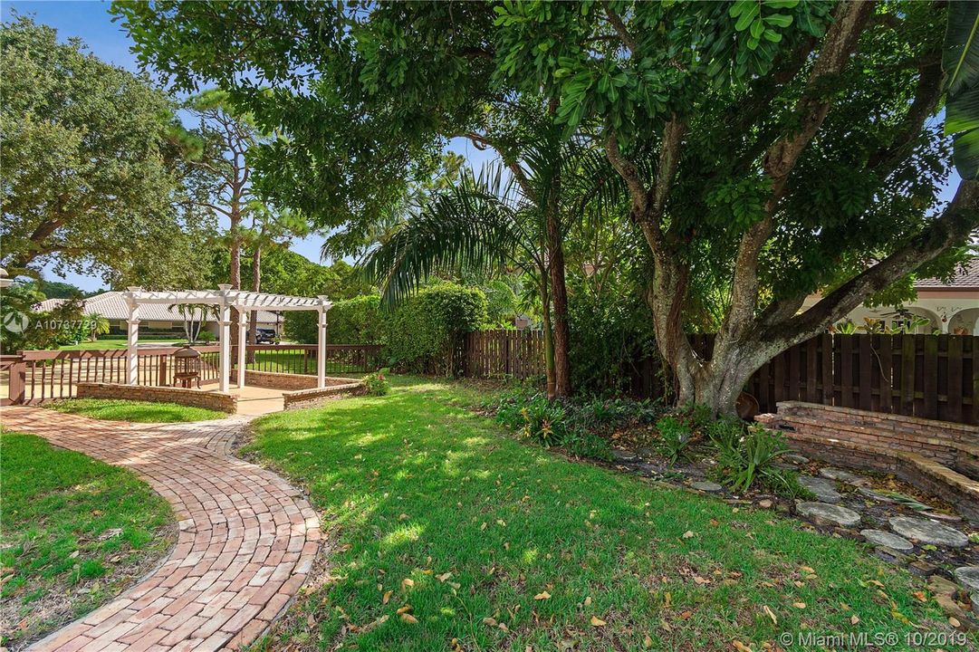 Such a large side yard with a Gazebo, Trellis and walkway leading to the side-loaded garage.