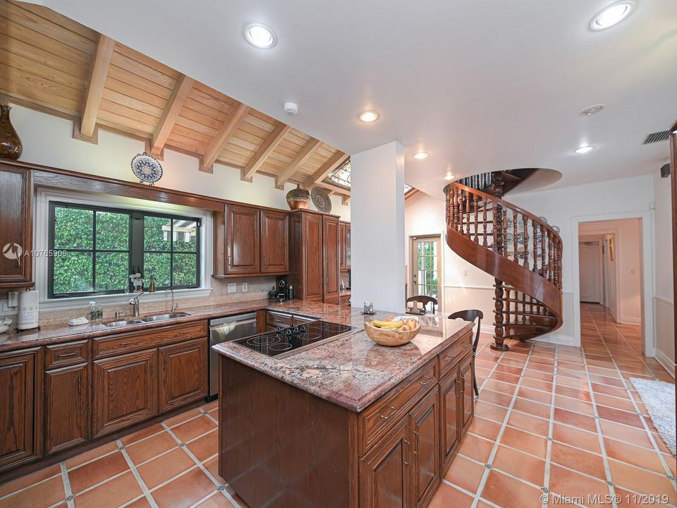 803 N. Greenway Dr., Coral Gables - Spacious chef's eat-in kitchen - Stairwell goes directly to the Master bedroom. Kitchen opens onto two different courtyards, one with the summer kitchen, other leading to the pool