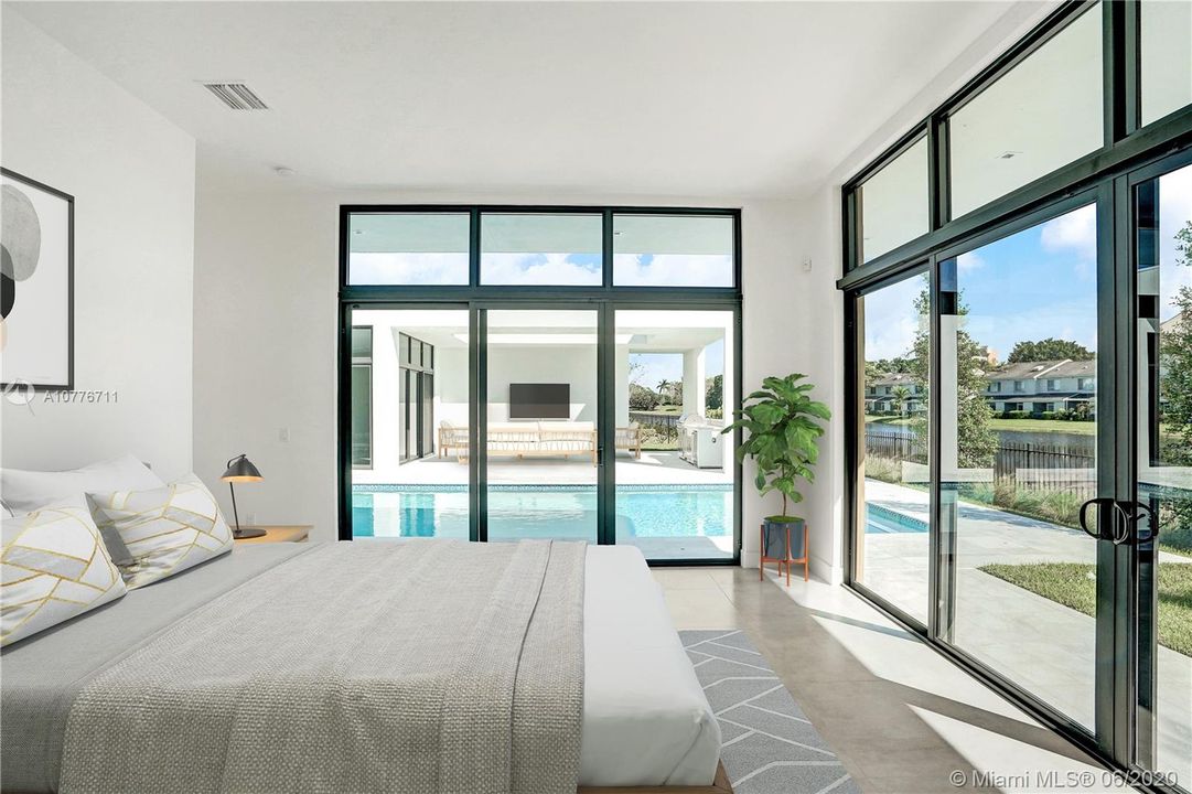 Master bedroom with beautiful lake and swimming pool views. Image virtually enhanced