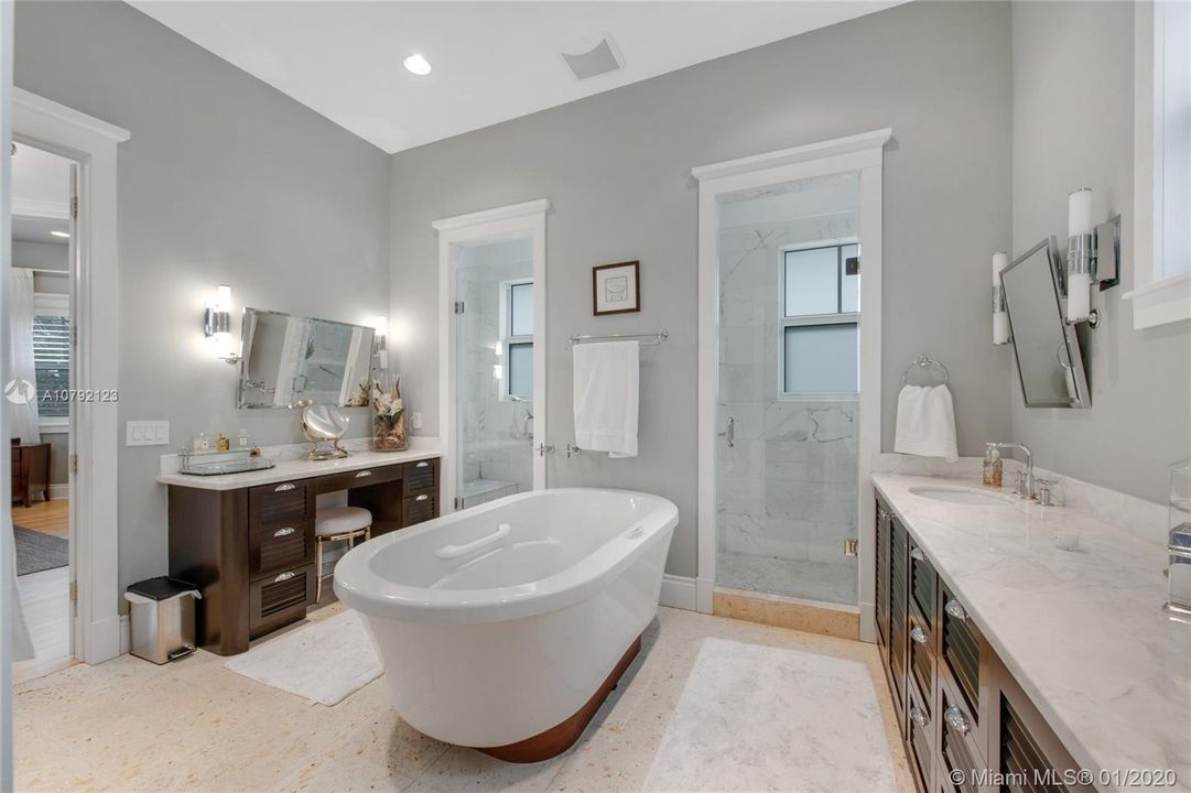 Master Bathroom with his & hers showers, his & hers sinks, sitting area and spa bathtub.