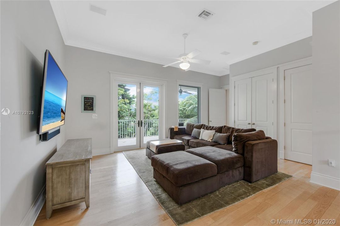 Second floor living area. Double glass impact doors lead to 2nd floor balcony, facing pool and waterway below. There is a wet bar kitchenette inside the double-door closet and space for a linen closet.