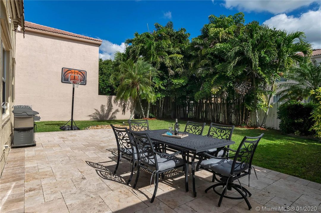 Fully fenced yard with room for pool plus travertine marble patio, perfect for entertaining