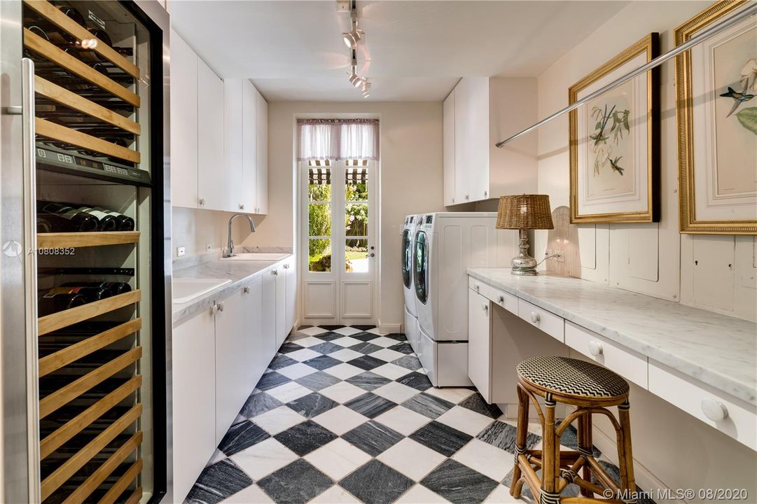 Laundry room equipped with 2 sinks, desk area, storage and wine refrigerator