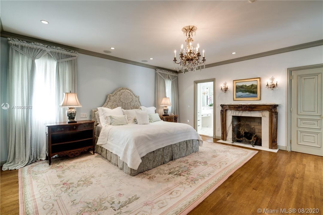 Master bedroom gives you warmth from fireplace and wood floors alike