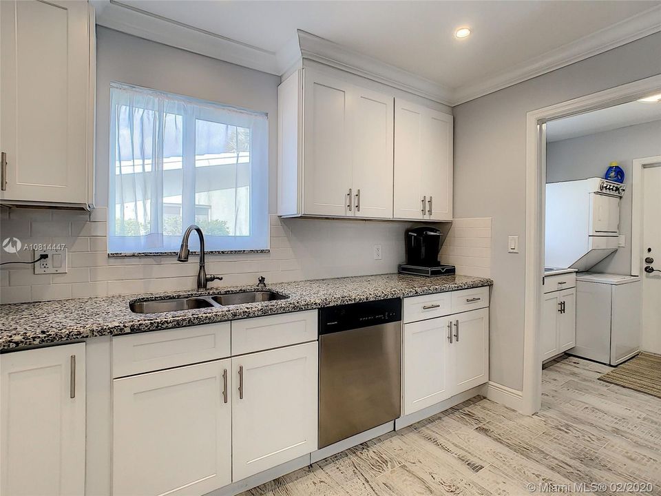 The sink overlooks the outside and is adjacent to the laundry/pantry room.