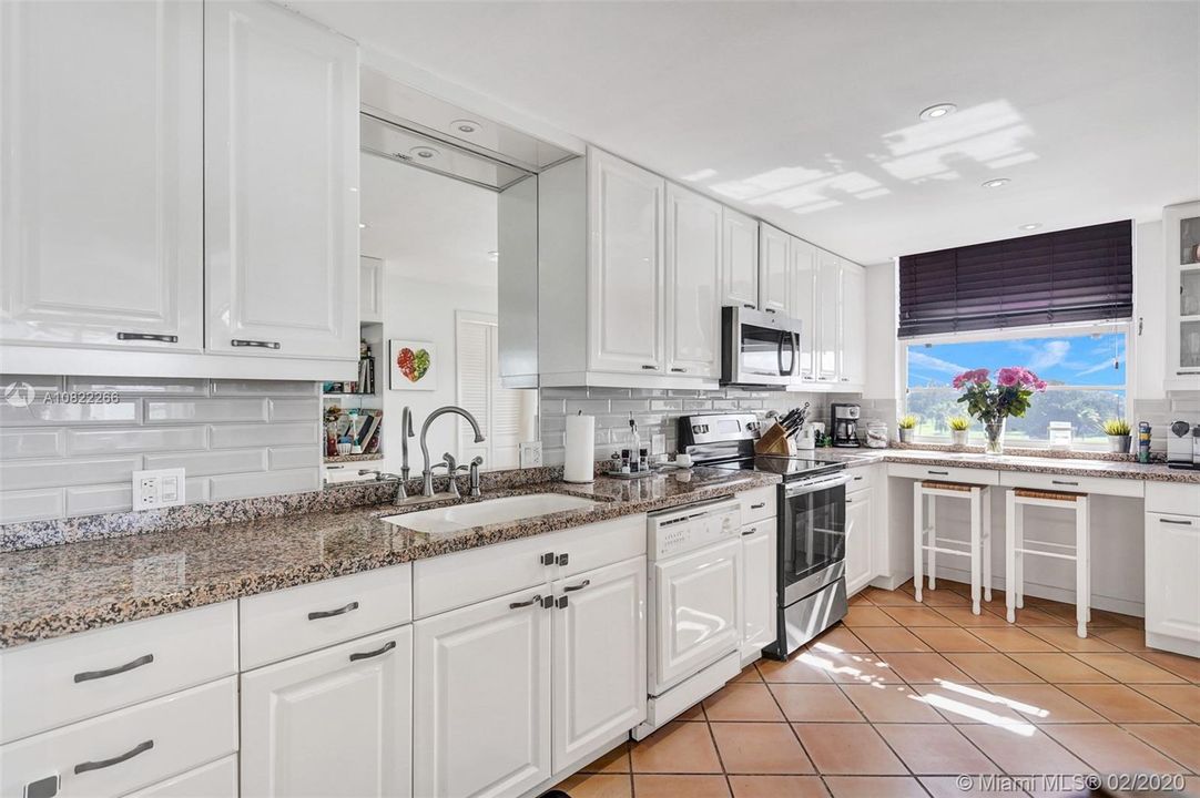 Gorgeous white kitchen with window overlooking the water
