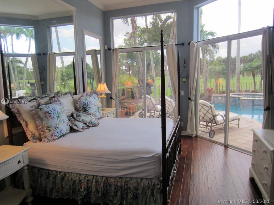 MASTER BEDROOM WITH HARDWOOD FLOORS WITH POOL AND GOLF COURSE VIEWS.