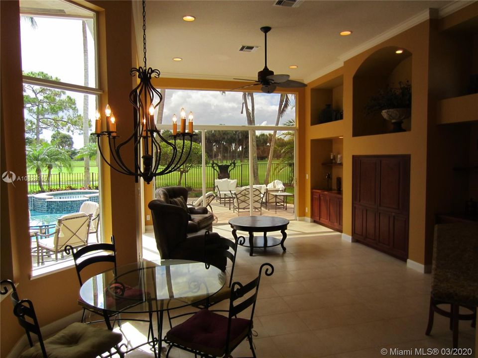 BREAKFAST AERA OVERLOOKING FAMILY ROOM WITH POOL AND GOLF COURSE VIEWS.