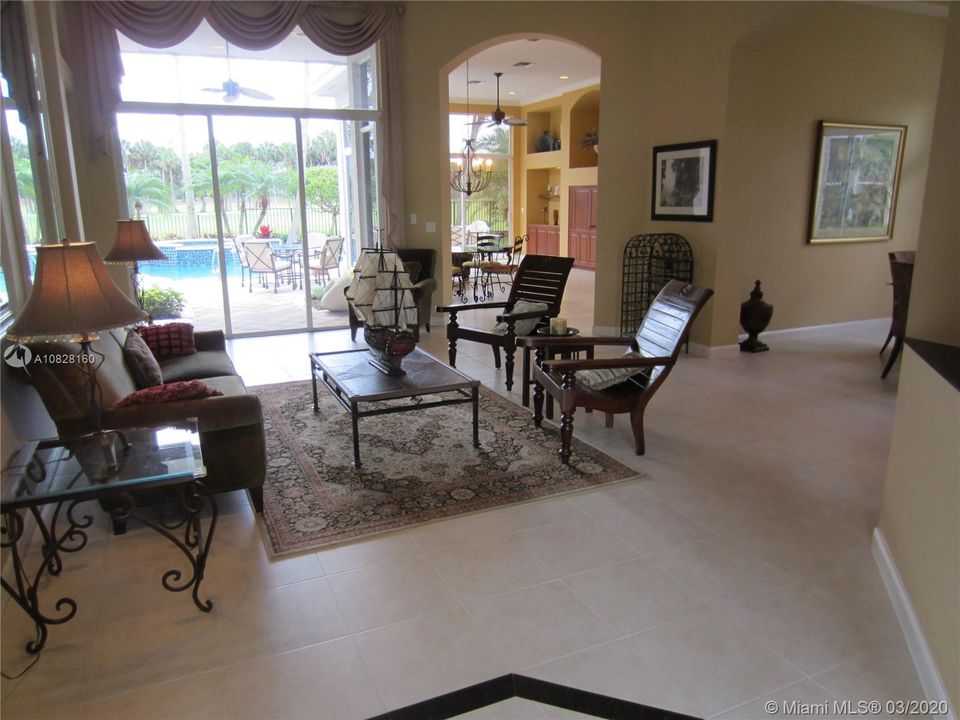 LIVING ROOM WITH POOL AND GOLF COURSE VIEWS.