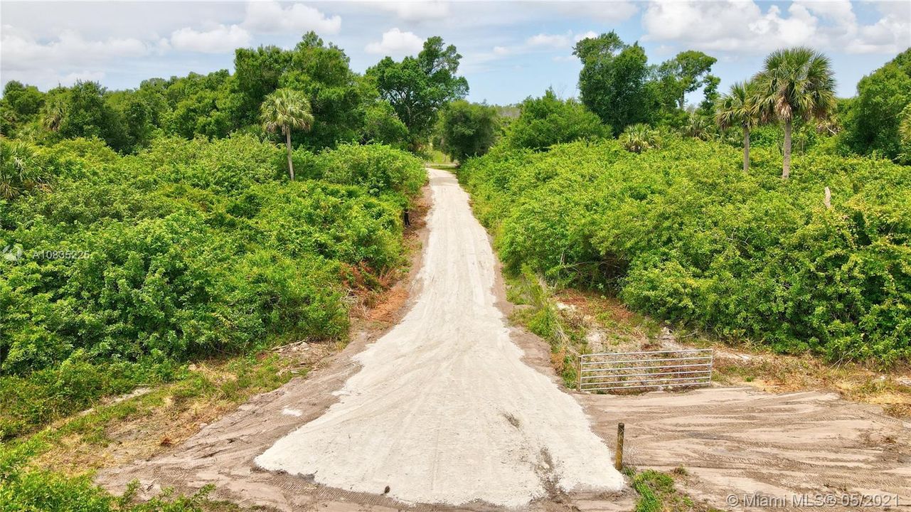 Road leading to gated entrance on right entrance to 5-acre parcel