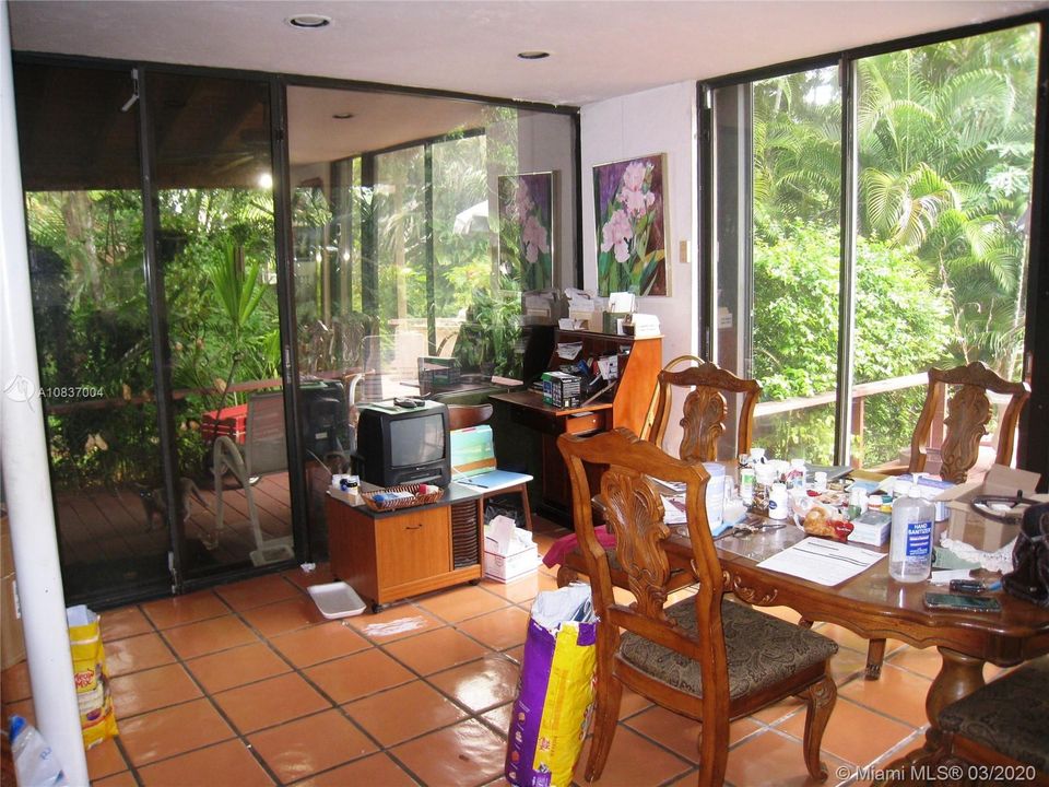 Dining room off kitchen with sliding glass doors leading to back open deck and covered decked patio on side