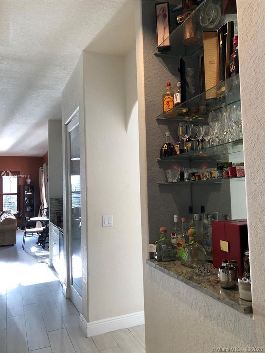 Custom built in bar with mirror and glass shelving