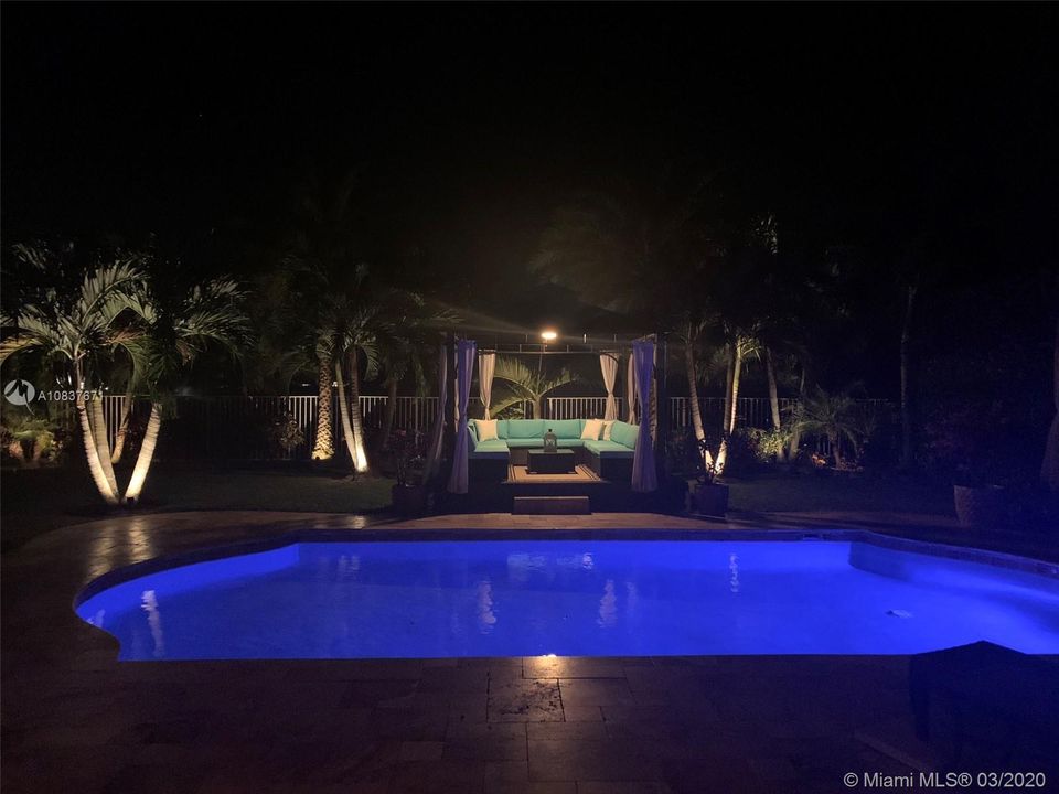 View from inside the house looking out at the pool at night