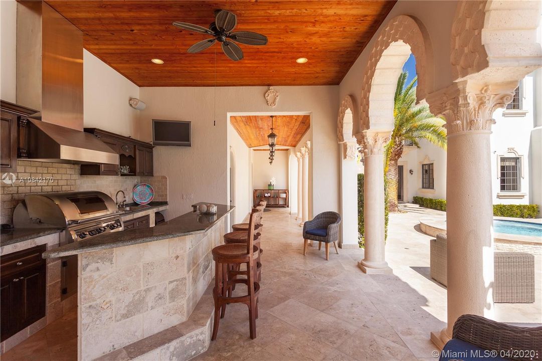 Fully equipped outdoor kitchen under columned arcade