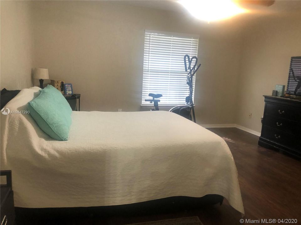 Spacious master bedroom, wood laminate floors & wood blinds