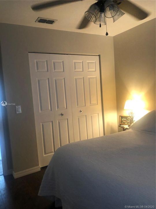 Bedroom 2, wood closet doors, and ceiling fan, wood laminate floors.