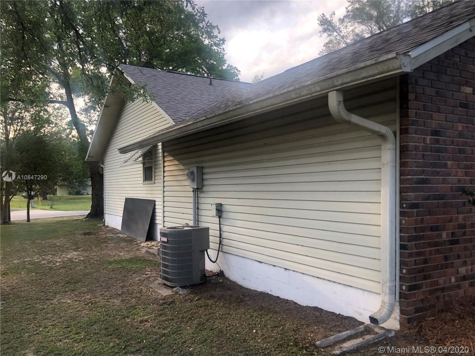 Side of home with paneling, rain gutters and A/C unit