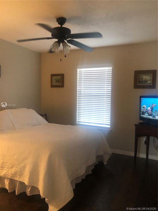 Bedroom 2, laminate wood floors, ceiling fan and wood blinds