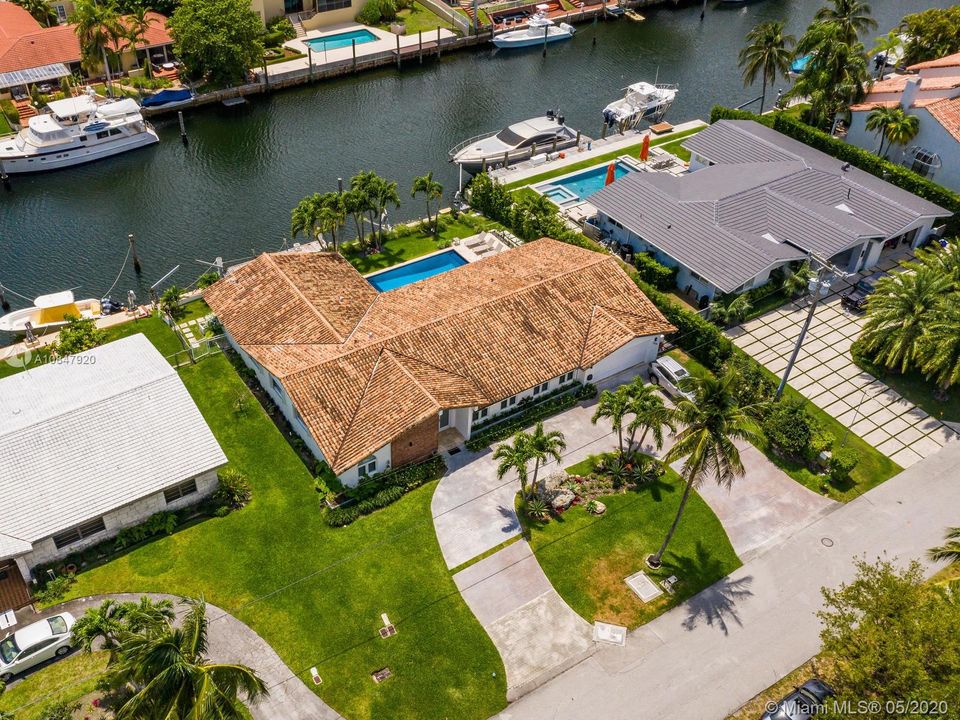 Aerial views of home with 11,500 sq ft lot, circular drive, 100 ft water frontage and newly renovated interior make this home ideal for indoor/outdoor living