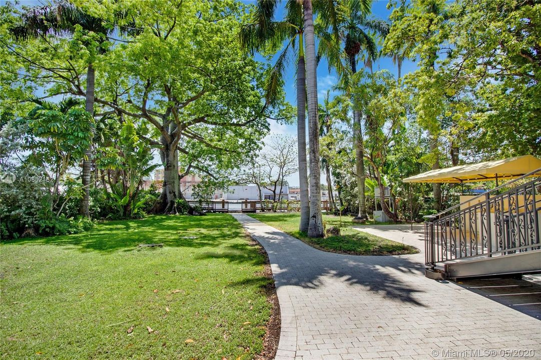 Garden pathways lead to dock and riverfront.
