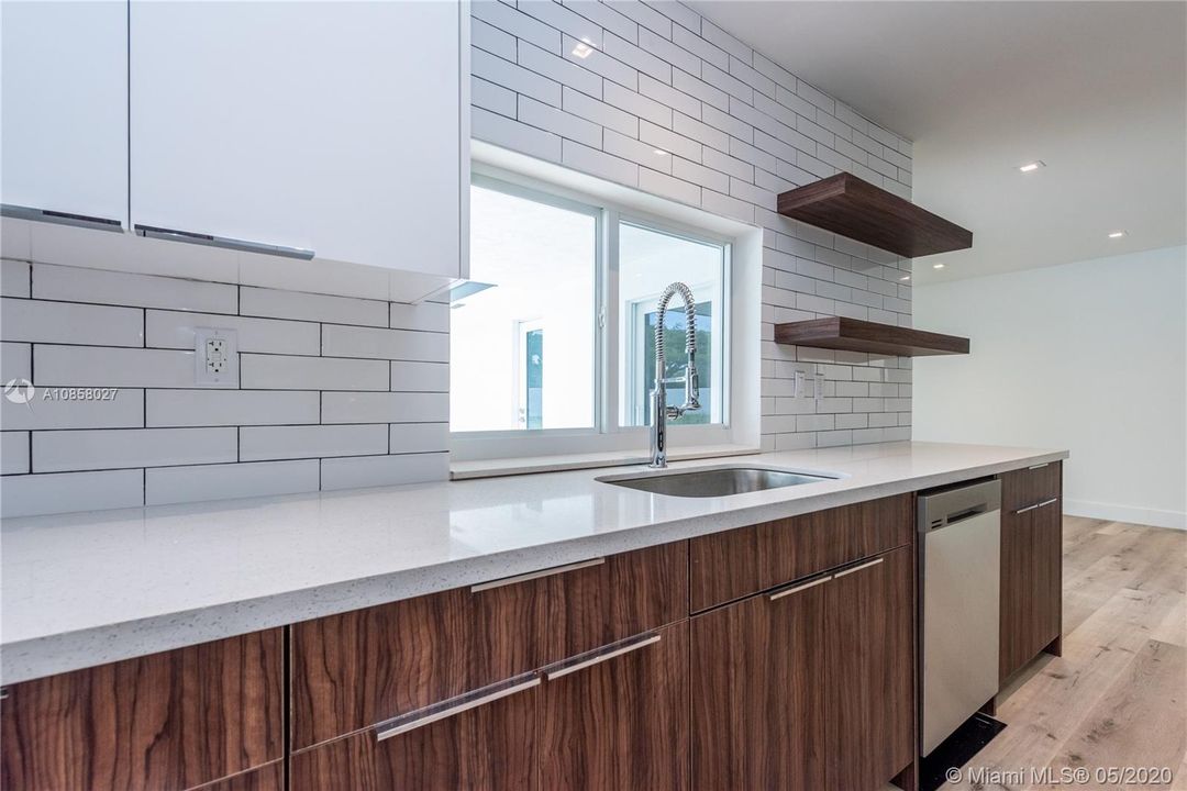 Detailed view of kitchen cabinetry and subway tile backsplash and wall.