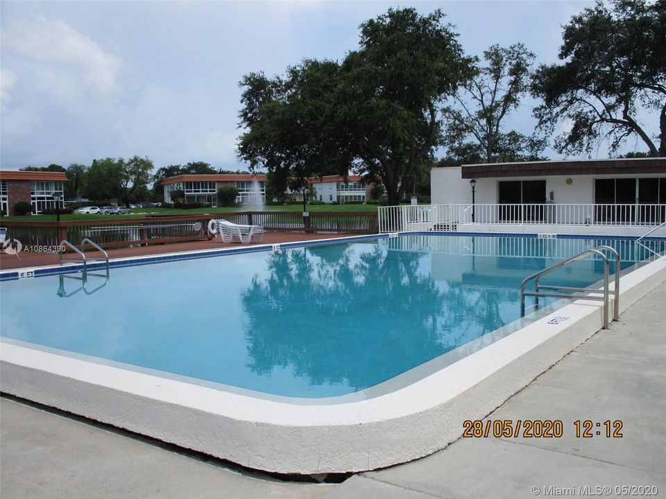 Over sized pool with a patio to left over looking the lake