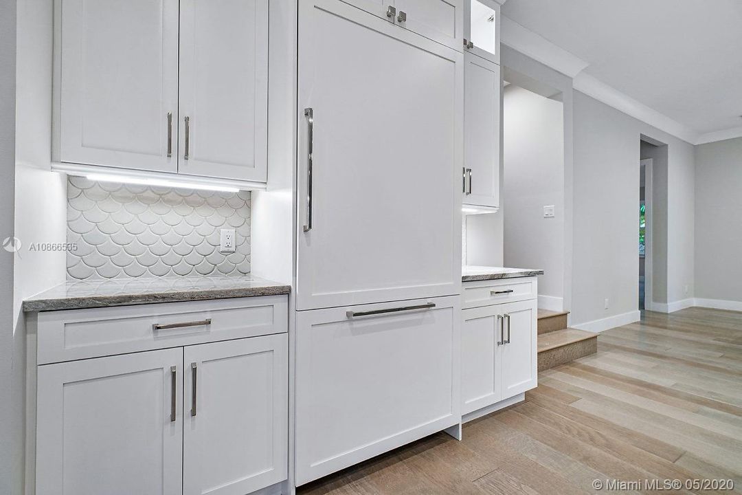 Custom cabinetry with cabinet panels over Thermador appliances.