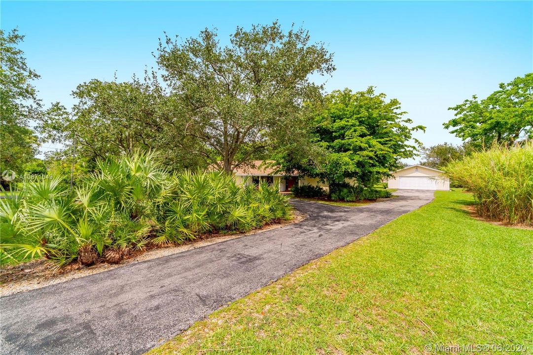 Driveway leading up to house and additional garage/workshop