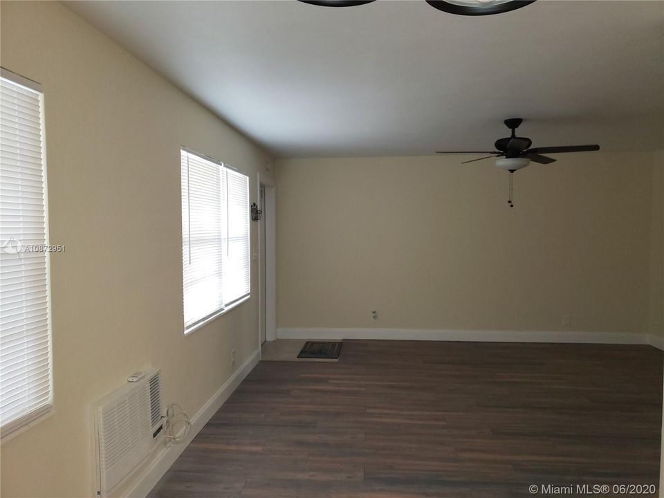 Large living area with wood floors and ceiling fan