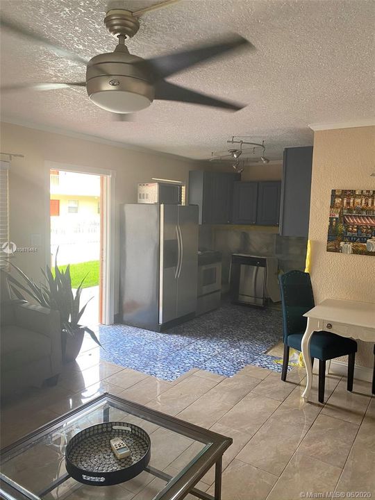 view of kitchen, dining and front door from living room