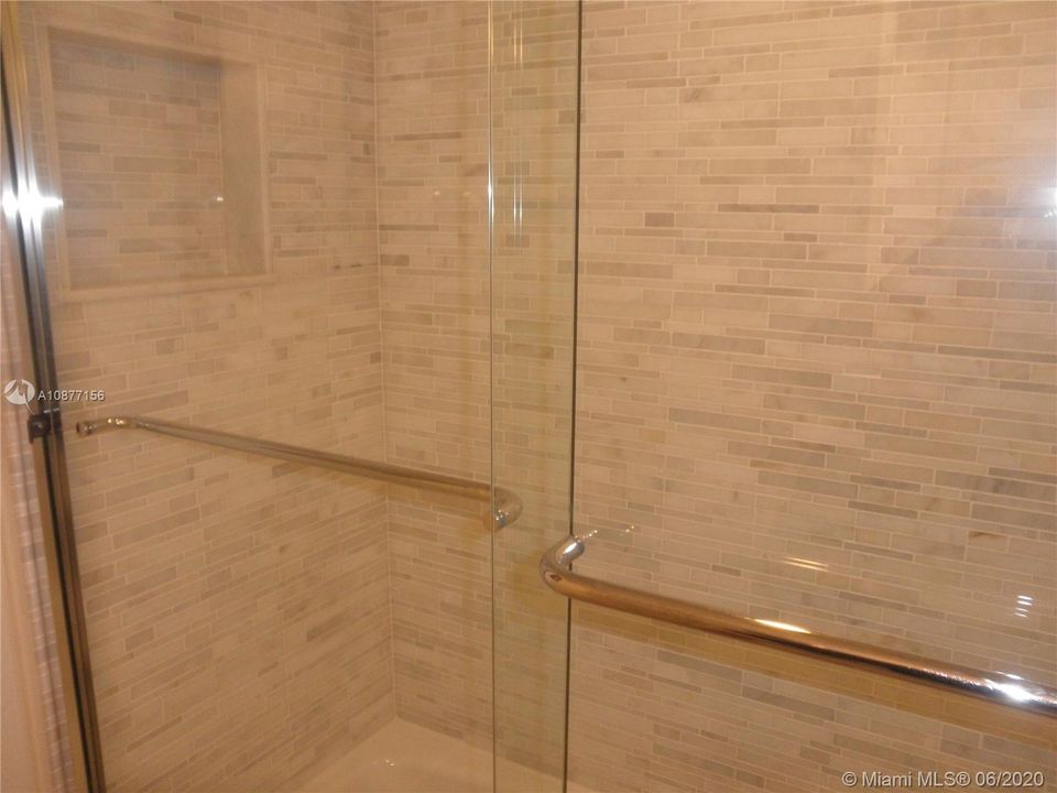 GUEST BATH HAS BATHTUB WITH MARBLE AND GLASS WET WALLSAND NOOK FOR BATH PRODUCTS