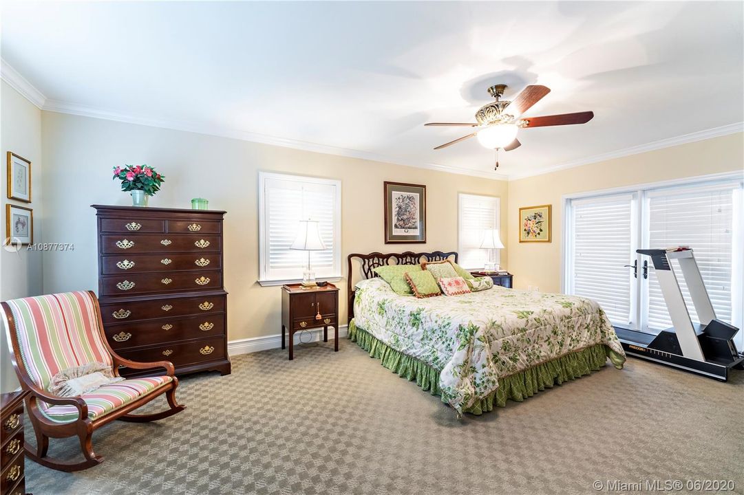 Spacious master bedroom with doors leading out to the patio.