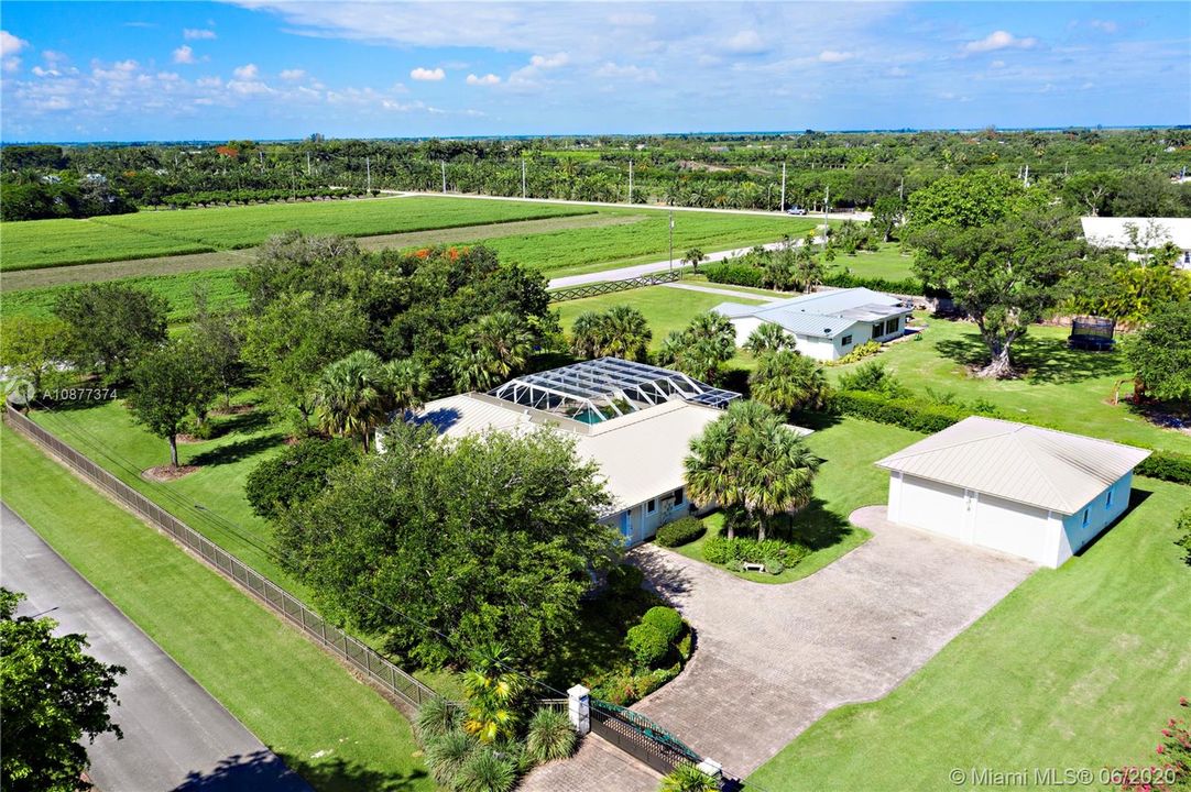 Fenced compound with electric gate and beautifully manicured yard.