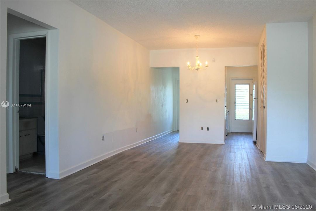 View from the living room back toward the kitchen on the right and the bathroom in the hallway on the left.