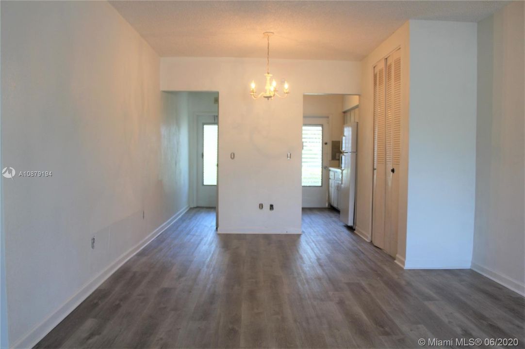 The view from the living room showing the 2 entrance doors and a 3rd storage closet on the right. The new waterproof flooring adds a nice touch to the condo.