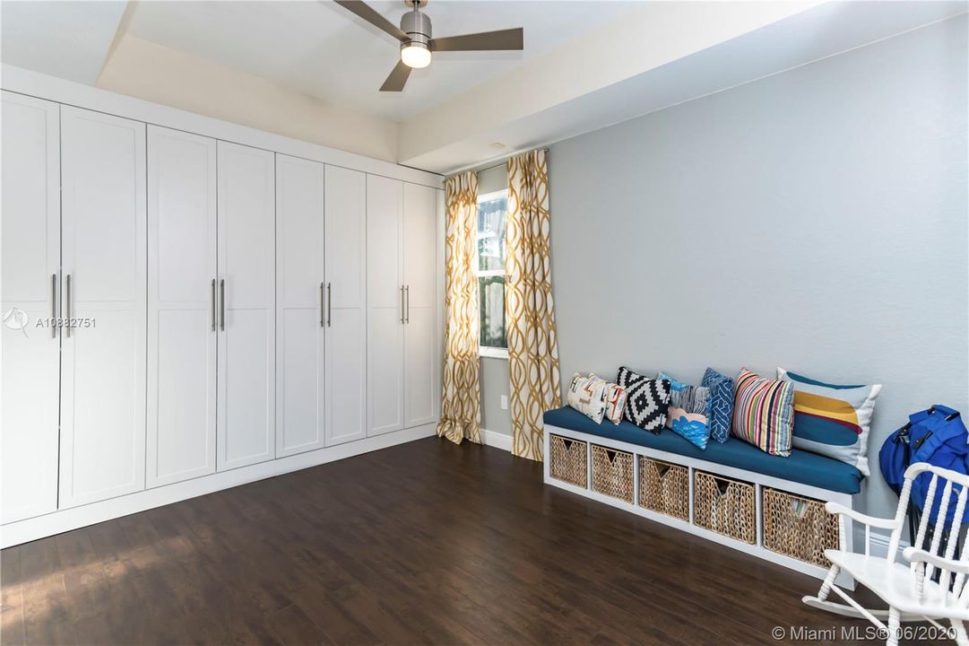 5th bedroom used as kids playroom with custom built closets/cabinets.