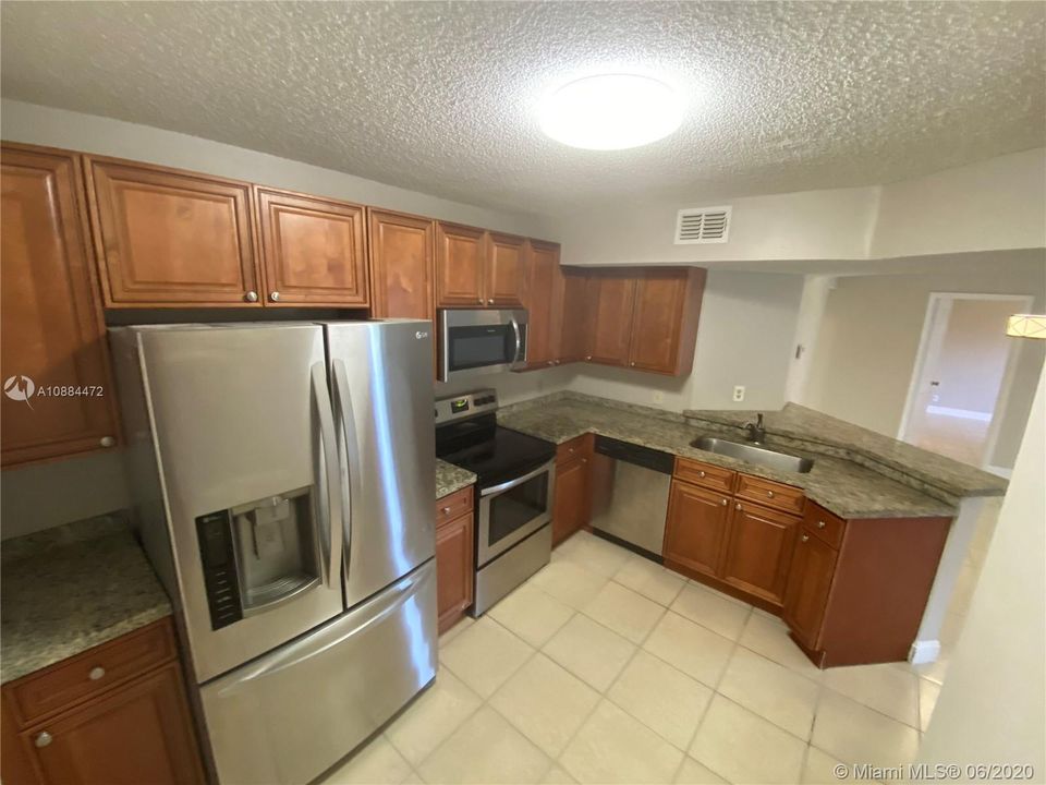 KITCHEN FEATURES MARBLE CABINETRY ,GRANITE COUNTER TOPS/SS APPLIANCES AND NICE PANTRY CLOSET.