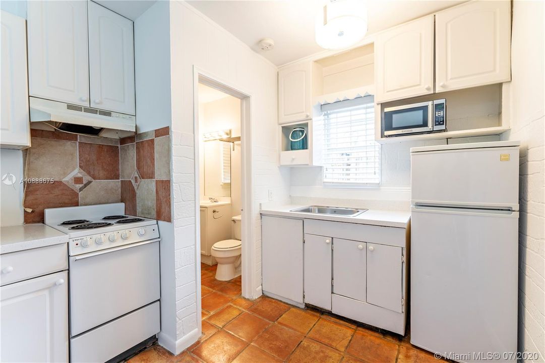 Guest cottage kitchen featuring range, refrigerator & microwave.