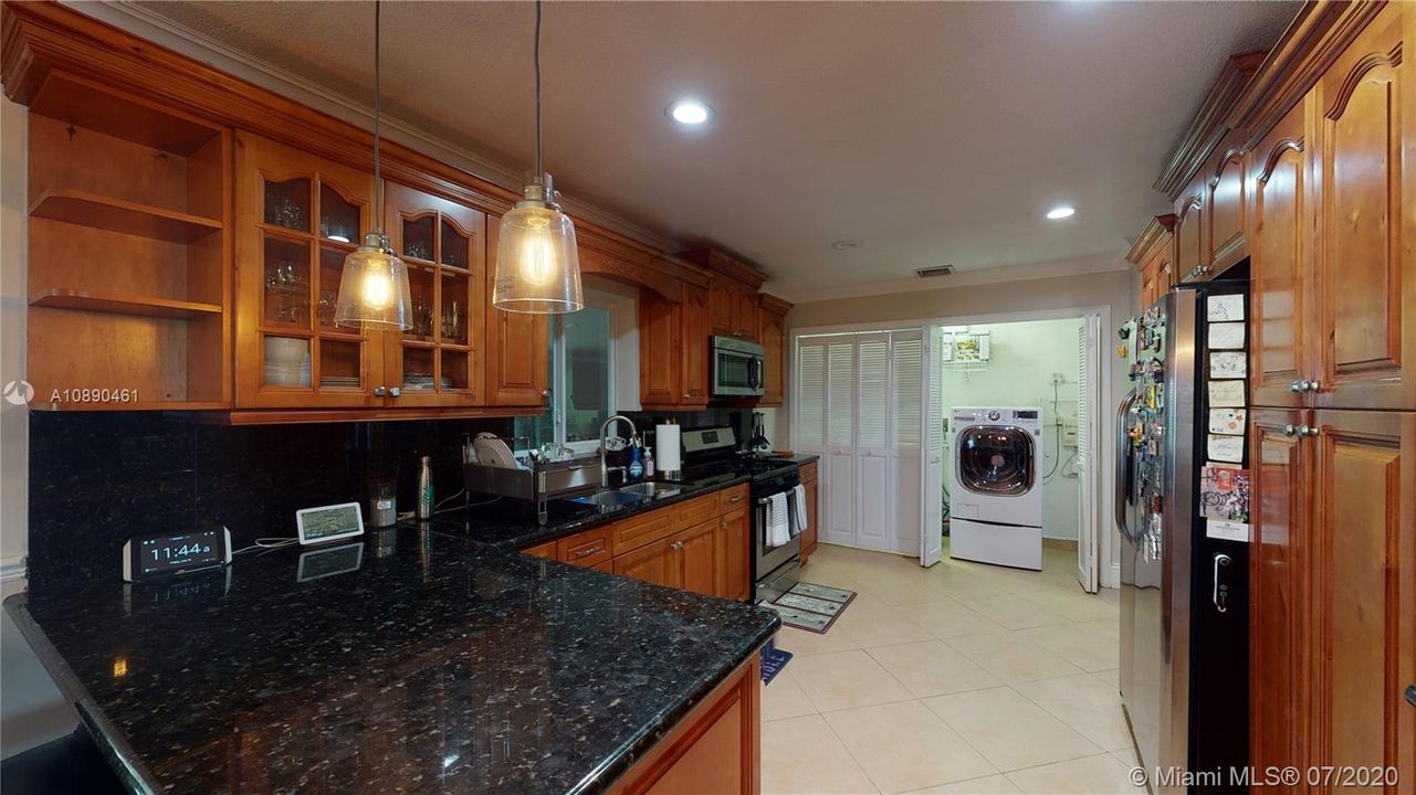 Kitchen with view of Washer Dryer Combo. It also includes a small load washer in the bottom drawer.