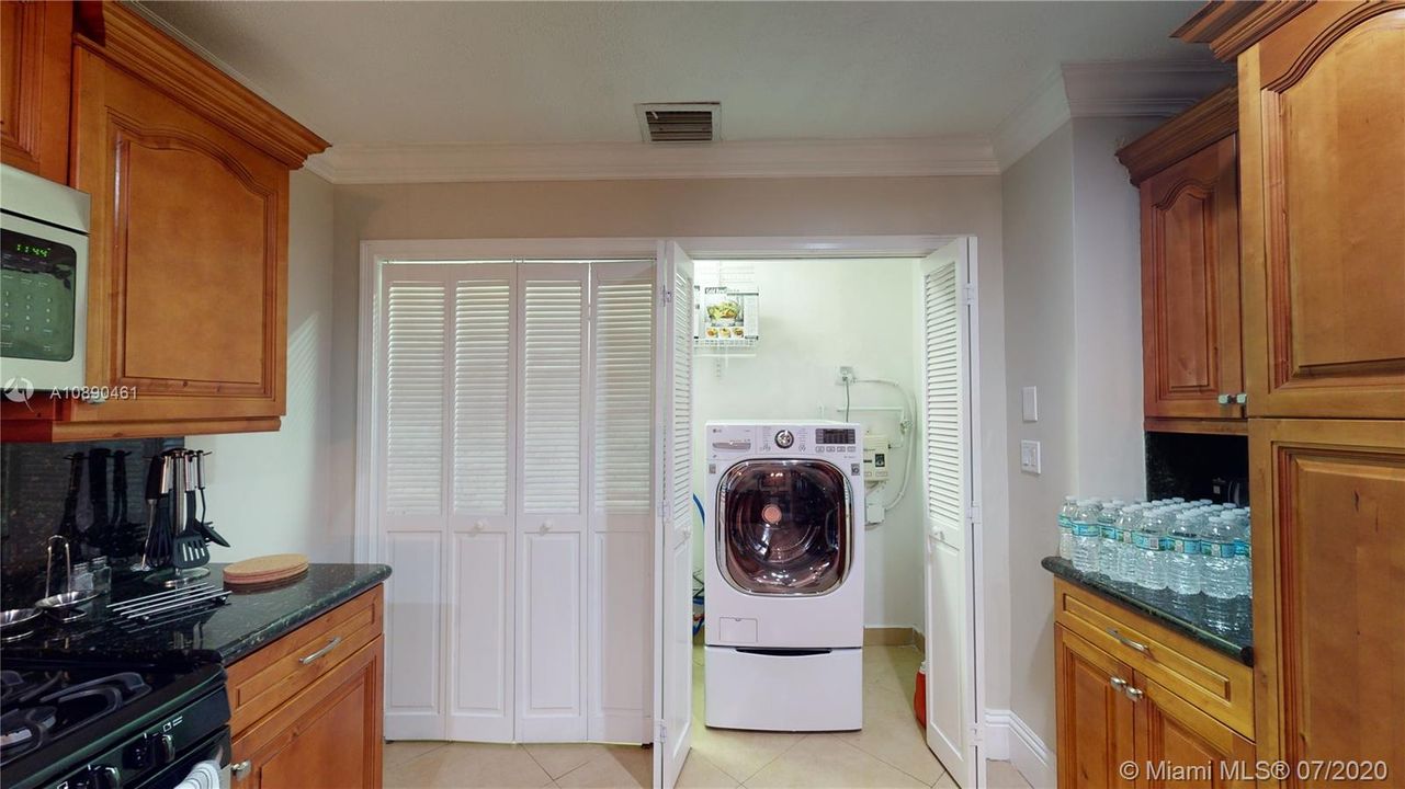 Kitchen with view of Washer Dryer Combo. It also includes a small load washer in the bottom drawer.