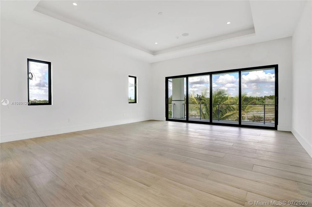 Primary suite, located on second floor with spacious balcony overlooking pool and preserve/water lot. Coffered ceilings.