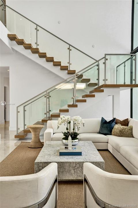 Custom floating staircase with glass & iron railing.